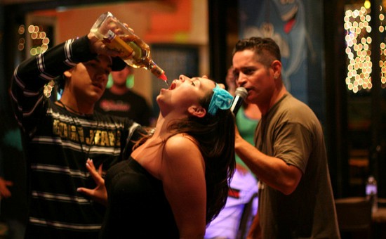 Pouring alcohol into someone's mouth